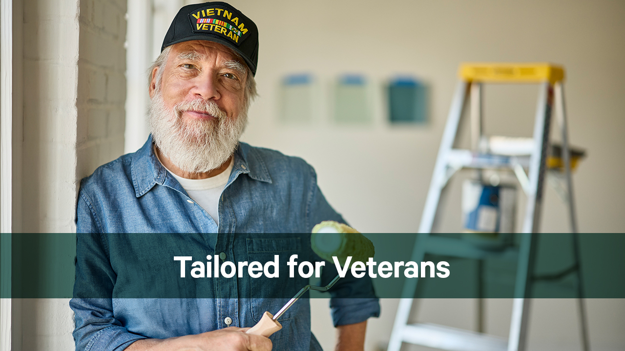 Veteran holding a paint roller smiles