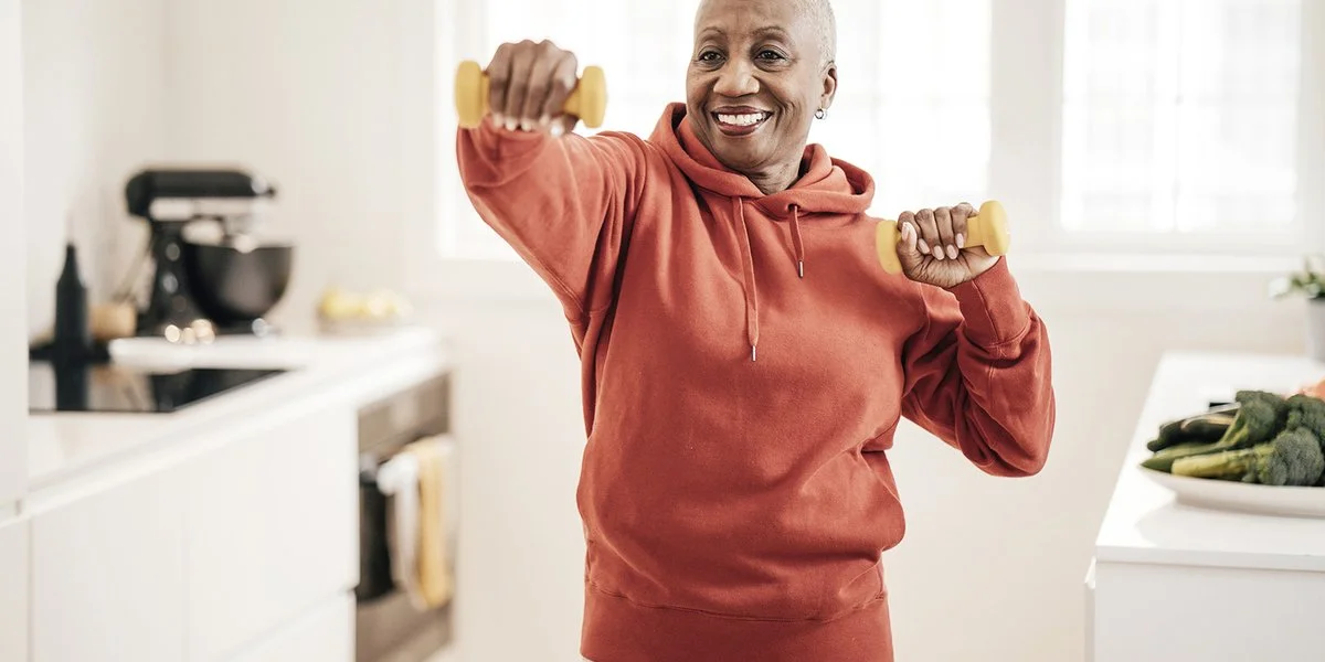 person in their kitchen holding weights doing an exercise