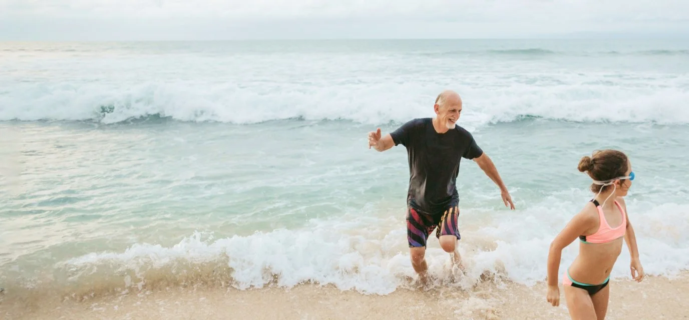 Grandfather playing with their grandchild on the beach