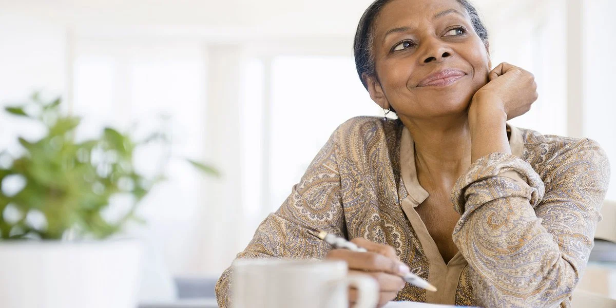 Woman smiling with her journal and pen in hand