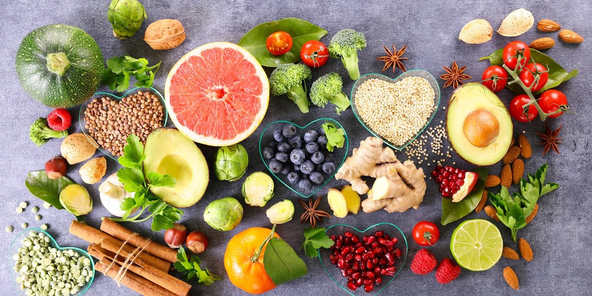 Variety of fruits and vegetables spread out on the grey surface