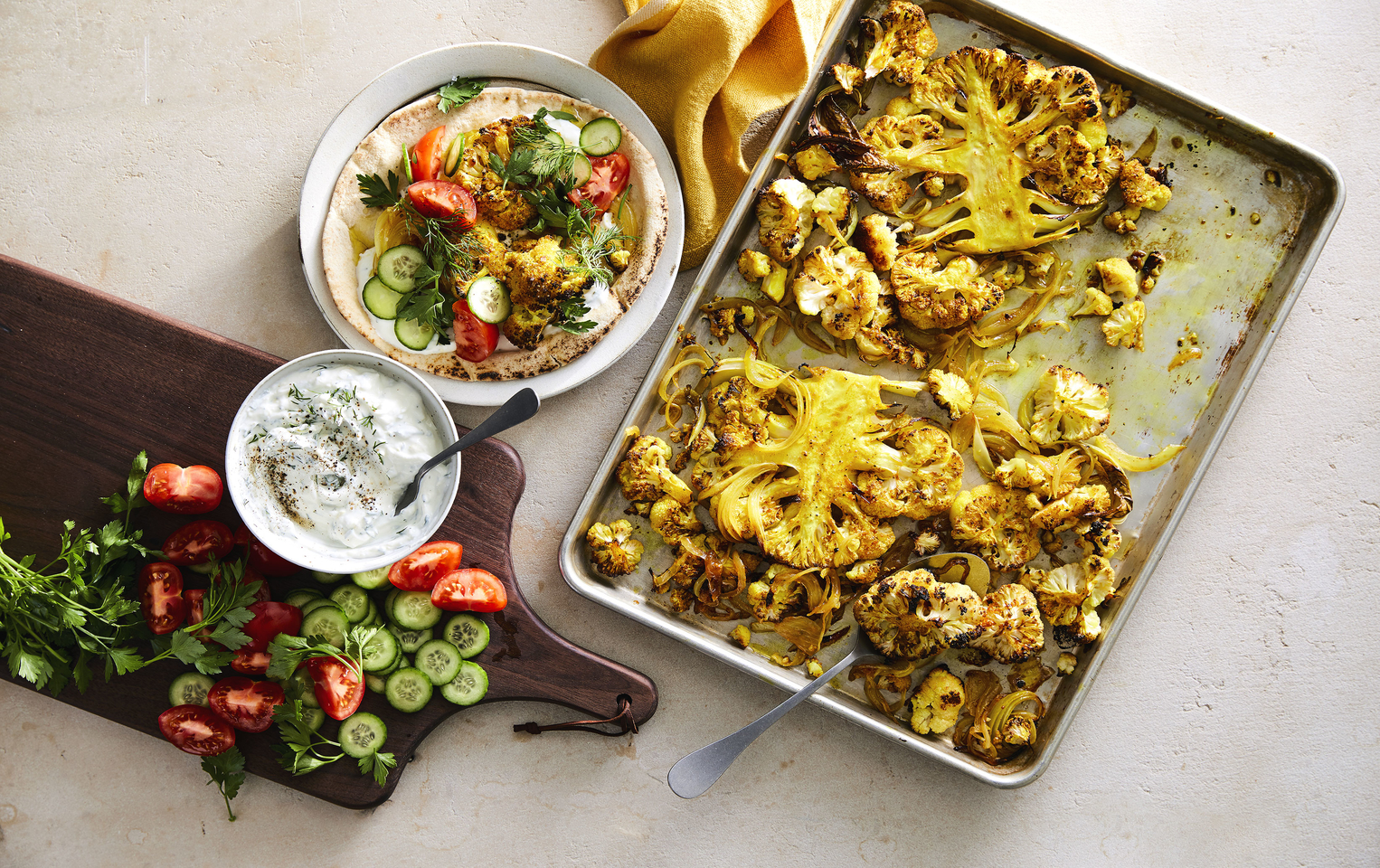 Shawarma cauliflower pita tzatziki plated on table with yellow napkin and silver spoon