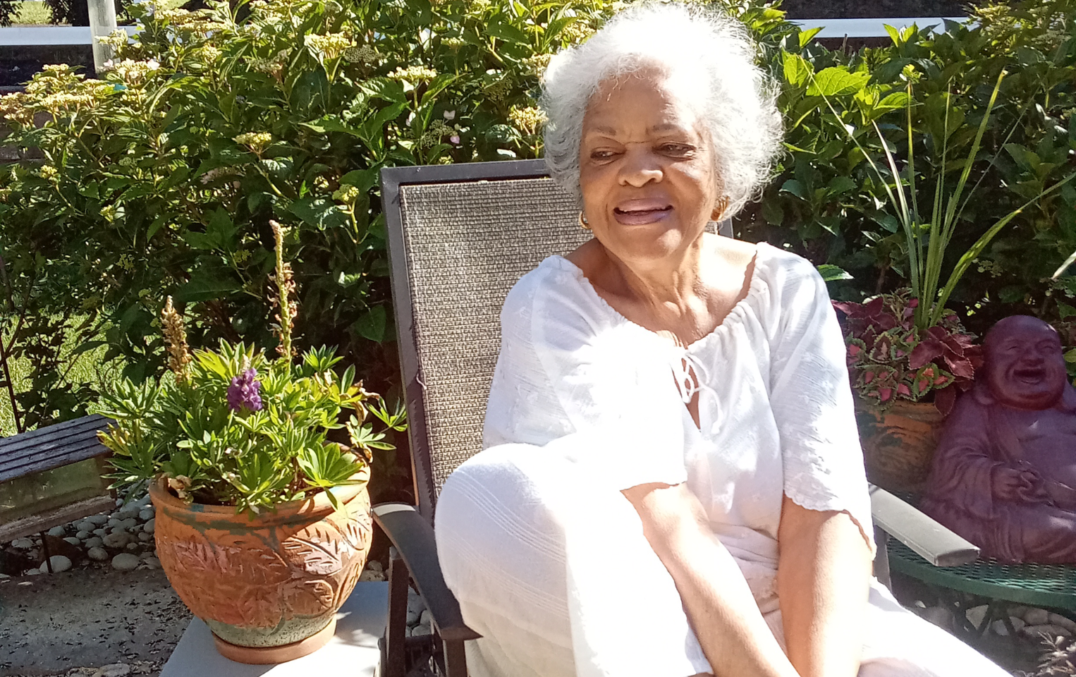 Member Myrna Harris sitting in her garden patio.