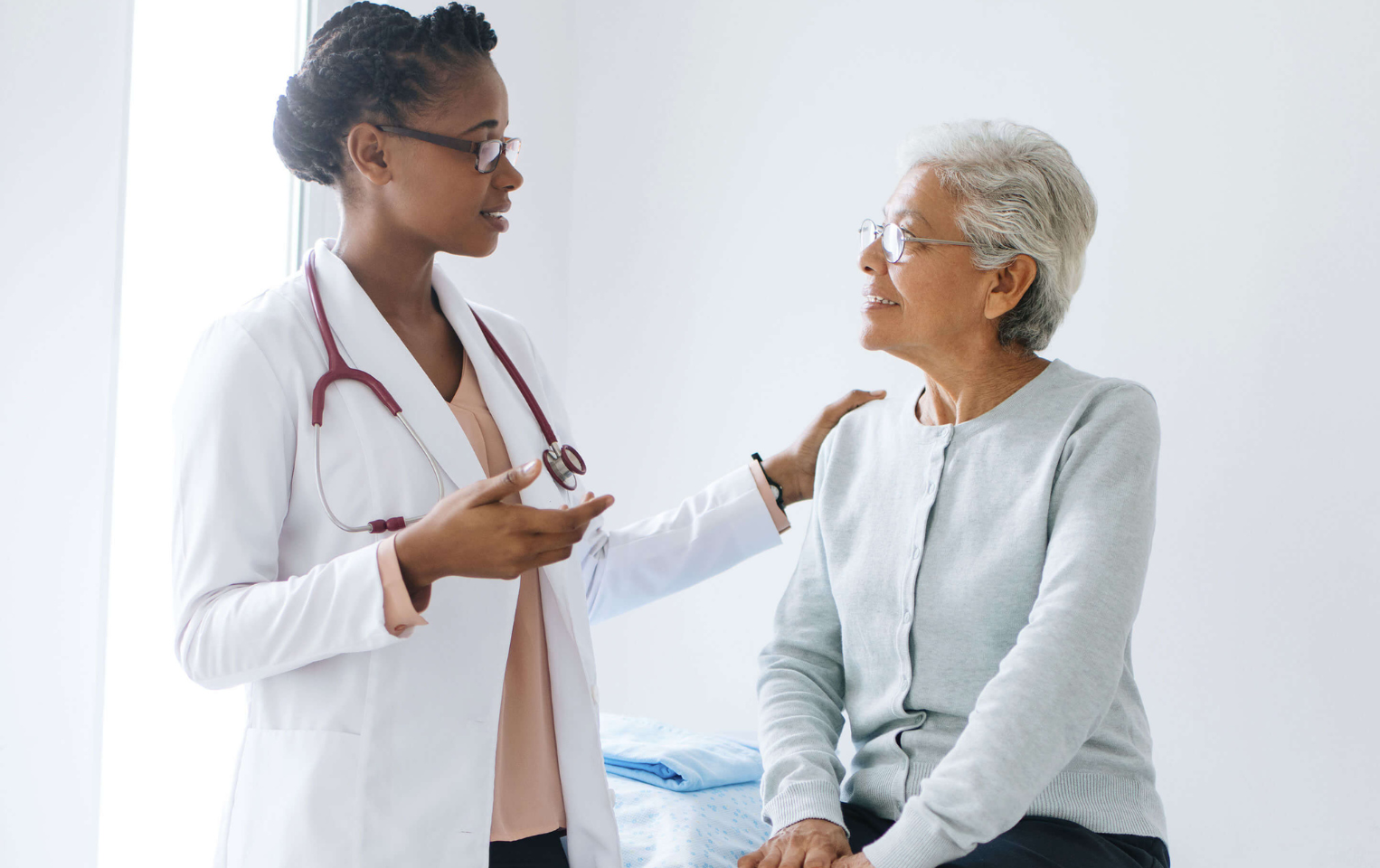 Doctor with a senior patient in an examining room.